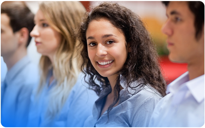 Smiling young person sitting with peers